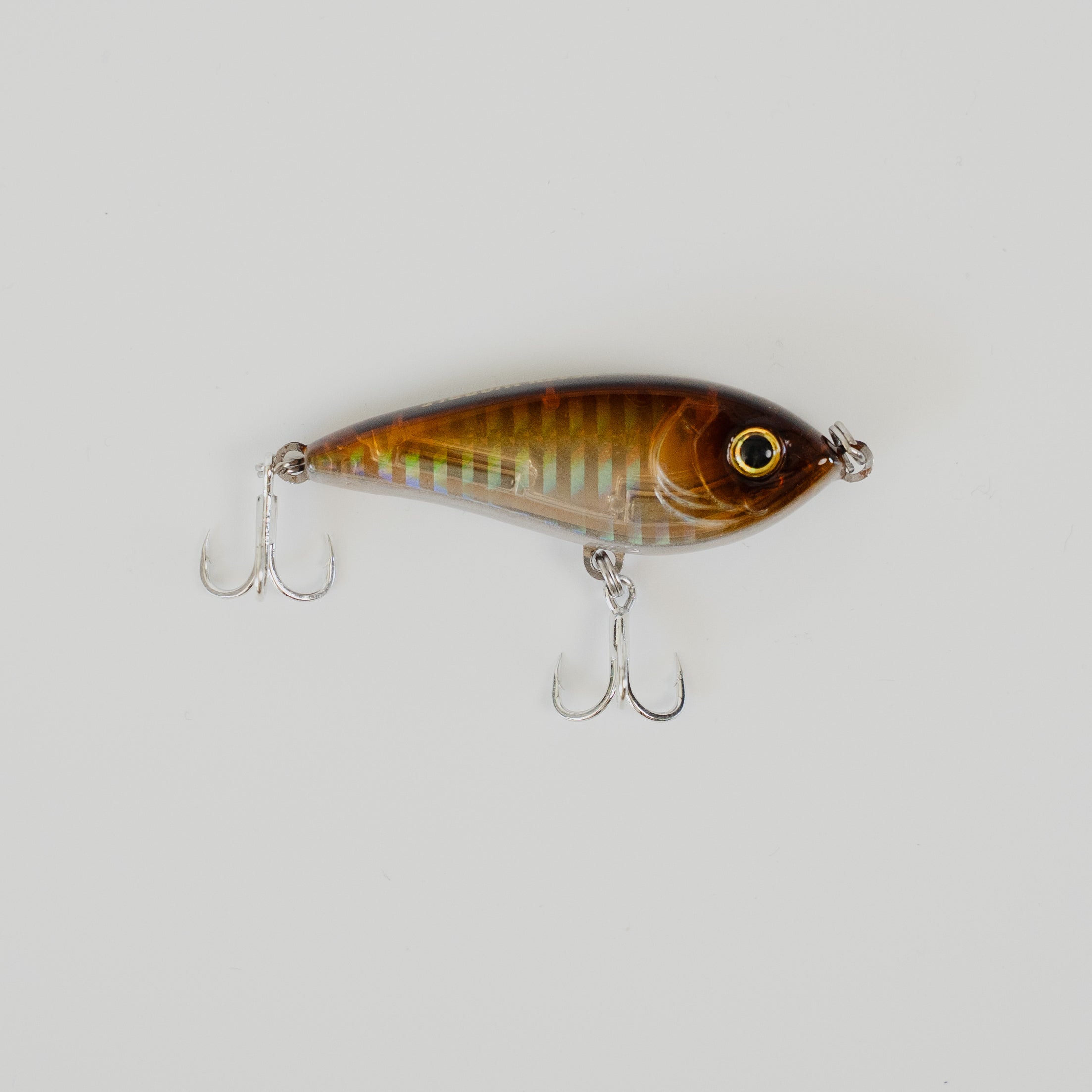 Fishing lure with a striped pattern on a light gray background